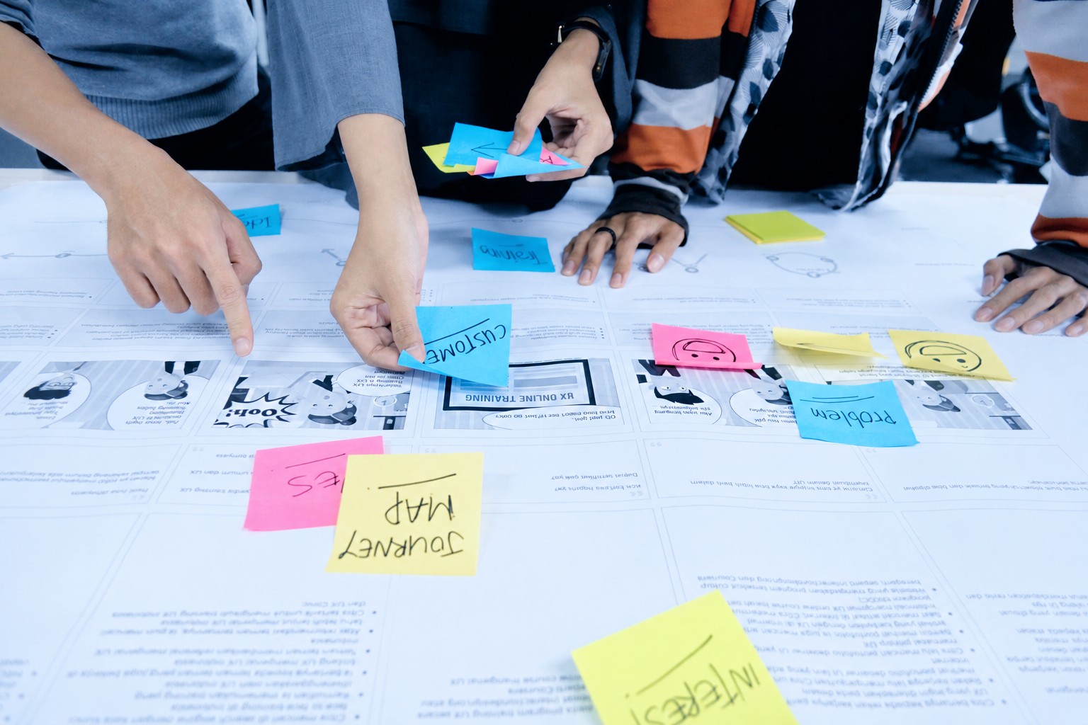 People collaborating around a table covered in sticky notes
